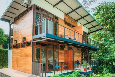 a house with a large deck with glass windows at Arenal Getaway in Fortuna
