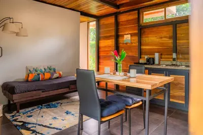 a dining room with a wooden table and chairs at Arenal Getaway in Fortuna