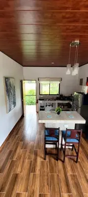 a kitchen with a table and chairs on a wooden floor at Villa Marina, Nosara in Nosara