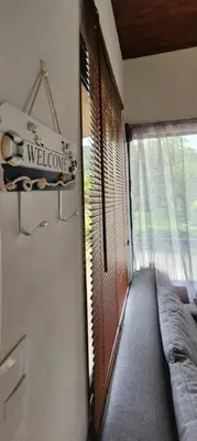 a room with a window with a couch and a welcome sign at Villa Marina, Nosara in Nosara