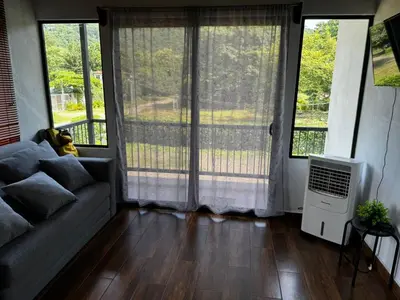 a living room with a couch and large windows at Villa Marina, Nosara in Nosara