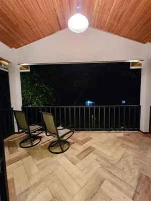 a patio with two chairs and a large screen at Itzá Casa Monteverde in Monteverde Costa Rica