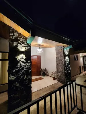 a lobby with a stone wall and a staircase at Itzá Casa Monteverde in Monteverde Costa Rica