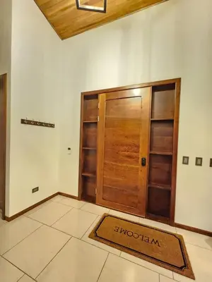 a room with a wooden door and a rug on the floor at Itzá Casa Monteverde in Monteverde Costa Rica