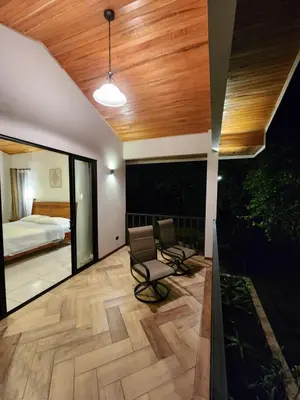 a bedroom with a bed and a chair in a room at Itzá Casa Monteverde in Monteverde Costa Rica