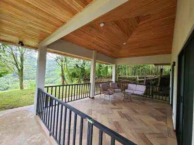 a porch with a wooden roof and a table and chairs at Itzá Casa Monteverde in Monteverde Costa Rica
