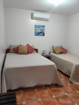 a bedroom with two beds and a window at Hotel Hacienda Casa del Viento in Cuajiniquil