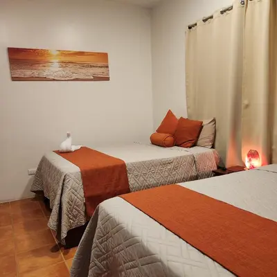 a room with two beds and a couch at Hotel Hacienda Casa del Viento in Cuajiniquil