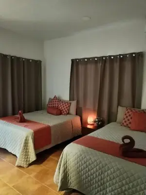 two beds in a room with curtains at Hotel Hacienda Casa del Viento in Cuajiniquil
