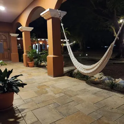 a hammock in a courtyard of a house at night at Hotel Hacienda Casa del Viento in Cuajiniquil