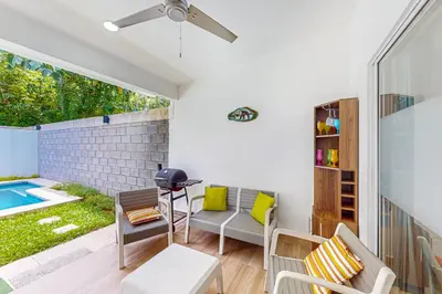 a living room with a patio and a swimming pool at Casa Eureka in Herradura
