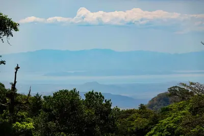 a view of a mountain range with clouds in the sky at Cabaña Indira in Monteverde Costa Rica