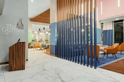 a lobby of a restaurant with chairs and tables at Hilton Garden Inn San Jose Airport City Mall in Alajuela City