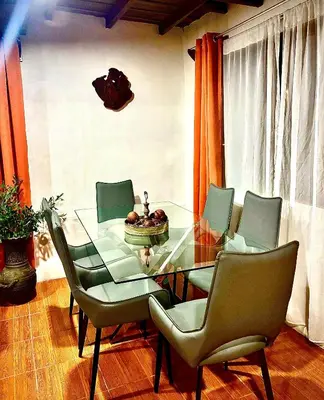a dining room with a glass table and chairs at Cabañas Litos #1 in Fortuna