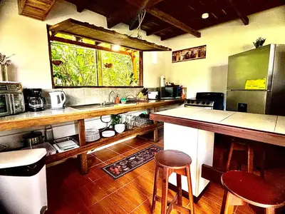 a kitchen with a counter and some stools in it at Cabañas Litos #1 in Fortuna