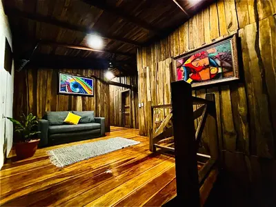 a living room with a couch and a painting on the wall at Cabañas Litos #1 in Fortuna