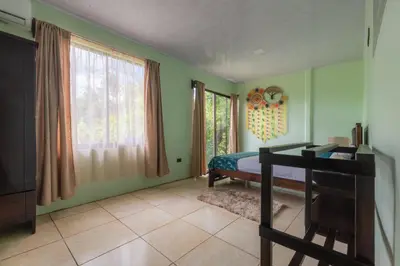a bedroom with green walls and a bed and windows at Vacation Home Bartenderluisch in Fortuna