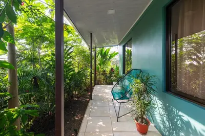 a patio with a blue house with a chair and plants at Vacation Home Bartenderluisch in Fortuna