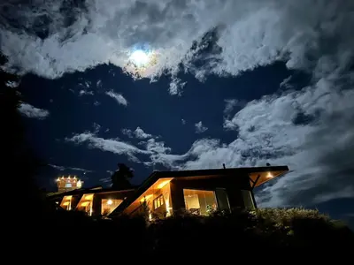 a house at night with the moon in the sky at Villas Páramo Cloud Forest Hotel in División