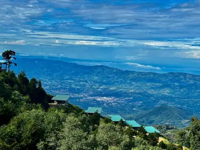 a view of a mountain with houses on a hill at Villas Páramo Cloud Forest Hotel in División