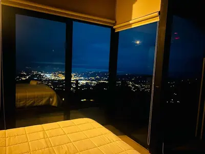 a bedroom with a view of a city at night at Villas Páramo Cloud Forest Hotel in División