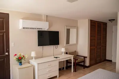 a room with a white desk and a tv on the wall at VistaMar - La Morada del Ocaso in Playa Hermosa