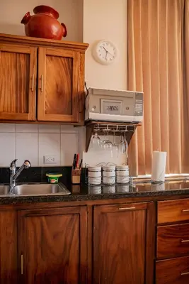 a kitchen with a sink and a clock on the wall at VistaMar - La Morada del Ocaso in Playa Hermosa