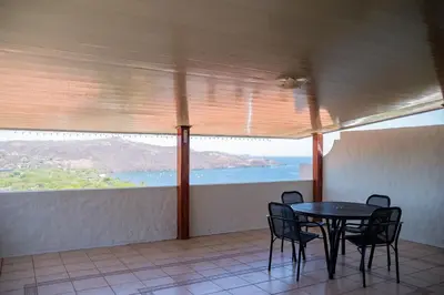 a table and chairs in a balcony with a view of the ocean at VistaMar - La Morada del Ocaso in Playa Hermosa