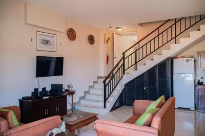 a living room with two couches and a staircase at VistaMar - La Morada del Ocaso in Playa Hermosa