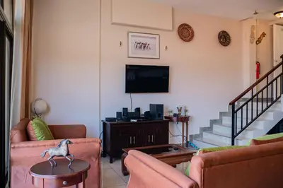 a living room with two couches and a tv at VistaMar - La Morada del Ocaso in Playa Hermosa