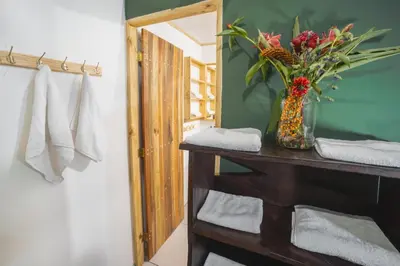 a bathroom with a table with a vase of flowers at Veragua Rainforest in Puerto Limón