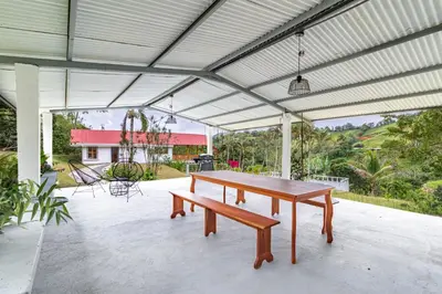 a patio with a wooden table and a bench at Finca Mango - 40 acre paradise in Roble