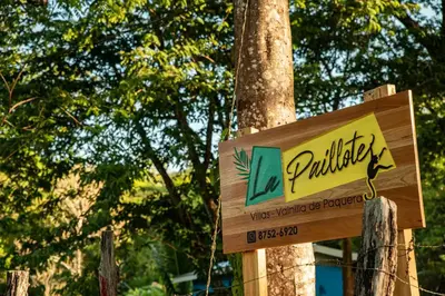 a wooden sign in front of a tree at Villas La Paillote Costa Rica in Puntarenas