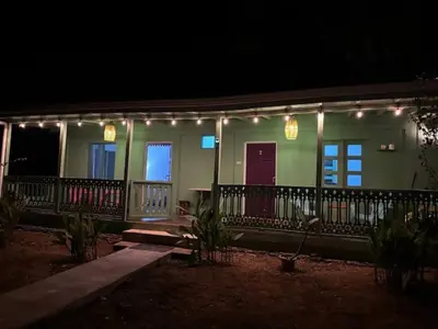 a house with lights on the balcony at night at Villas La Paillote Costa Rica in Puntarenas