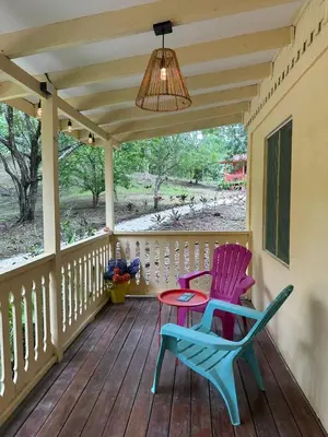 two chairs and a table on a porch at Villas La Paillote Costa Rica in Puntarenas
