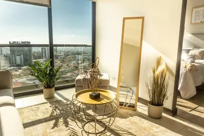 a living room with a table and a view of a city at Rooftop - 18th Floor Apt City View in Mata de Palo