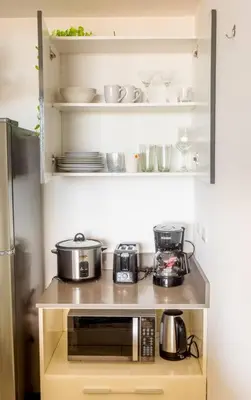 a small kitchen with pots and pans on a shelf at Rooftop - 18th Floor Apt City View in Mata de Palo