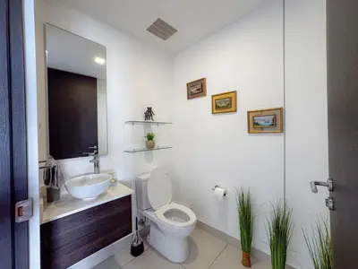 a white bathroom with a toilet and a sink at Rooftop - 18th Floor Apt City View in Mata de Palo