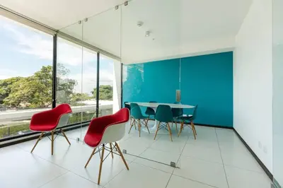 a dining room with red chairs and a blue wall at Rooftop - 18th Floor Apt City View in Mata de Palo