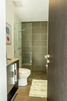 a bathroom with a toilet and a glass shower at Rooftop - 18th Floor Apt City View in Mata de Palo