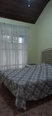 a bedroom with a large bed with a window at Casa Mora in Jacó