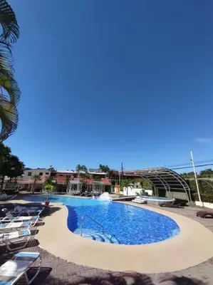 a large swimming pool with chairs around it at Casa Mora in Jacó