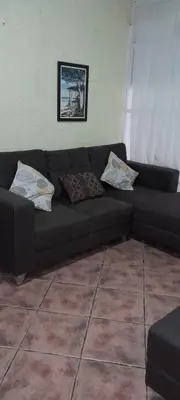 a black couch in a living room with pillows at Casa Mora in Jacó