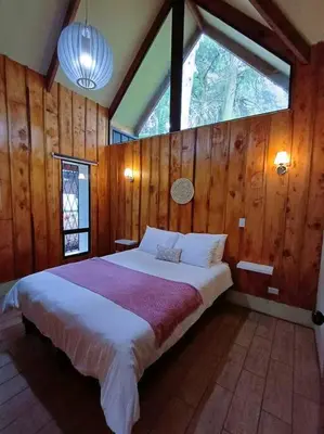 a bedroom with a large bed and a window at Les Chalets Costa Rica in Zarcero