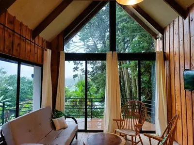 a living room with a couch and a large window at Les Chalets Costa Rica in Zarcero