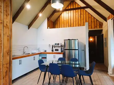 a kitchen with a glass table and blue chairs at Les Chalets Costa Rica in Zarcero