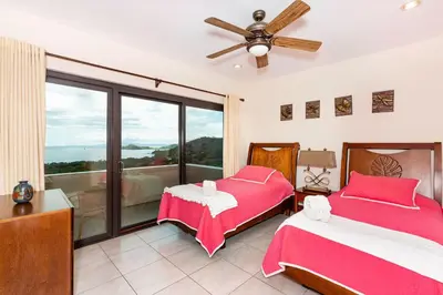 a bedroom with two beds and a balcony at Casa Antonelli 4br Infinity Pool Pet Friendly in Playa Hermosa