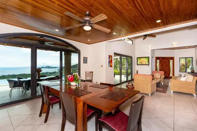 a dining room with a table and a ceiling fan at Casa Antonelli 4br Infinity Pool Pet Friendly in Playa Hermosa