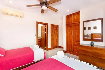 a bedroom with two beds and a ceiling fan at Casa Antonelli 4br Infinity Pool Pet Friendly in Playa Hermosa