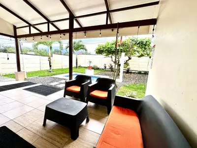 a patio with two chairs and a table at Oasis Arenal Villa Pool & Arenal Volcano View in Fortuna